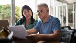 Middle-aged couple looks at refinance paperwork in their home