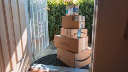Large stack of Amazon boxes sitting on the front porch on a sunny day