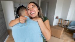 A young couple hugs in the kitchen holding the keys to their new home